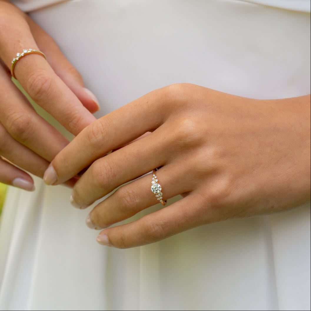 Brautmodel trägt Verlobungsring mit kleinen Seitendiamanten