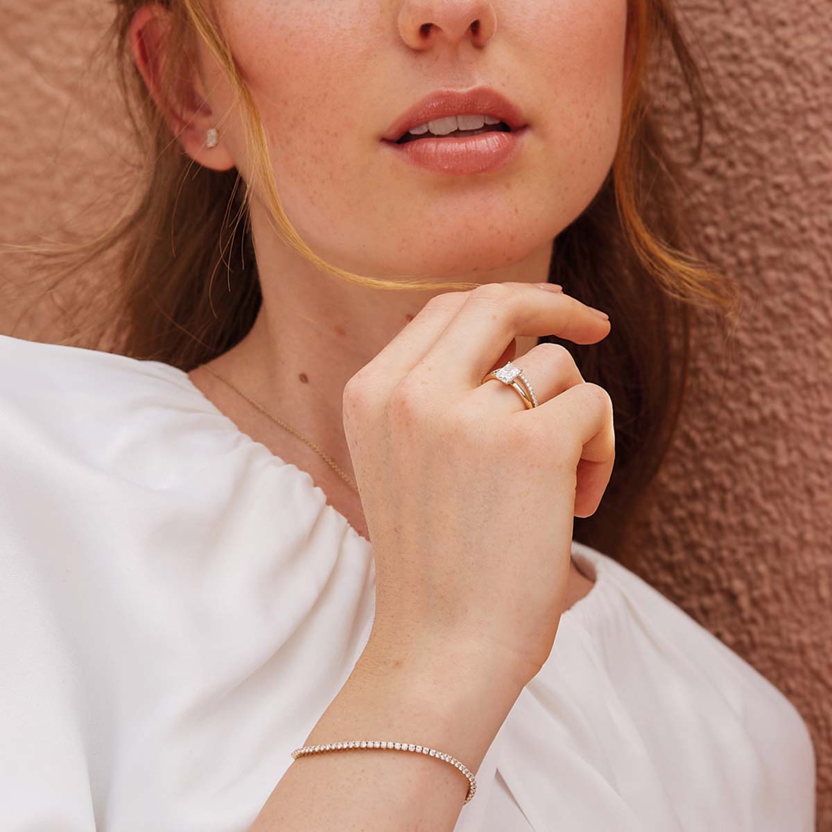 Model trägt Radiant-Verlobungsring mit Lab-Diamanten in Gelbgold