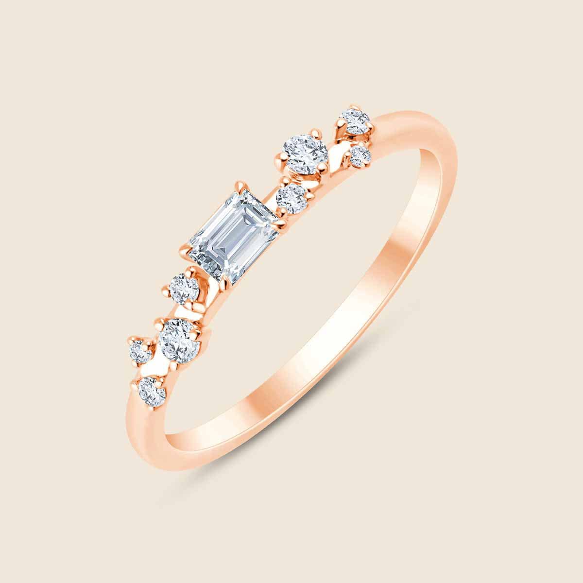 Ring rosefarbend mit kleinen versetzten Lab Diamanten, mittig Diamant in Emarald-Schliff