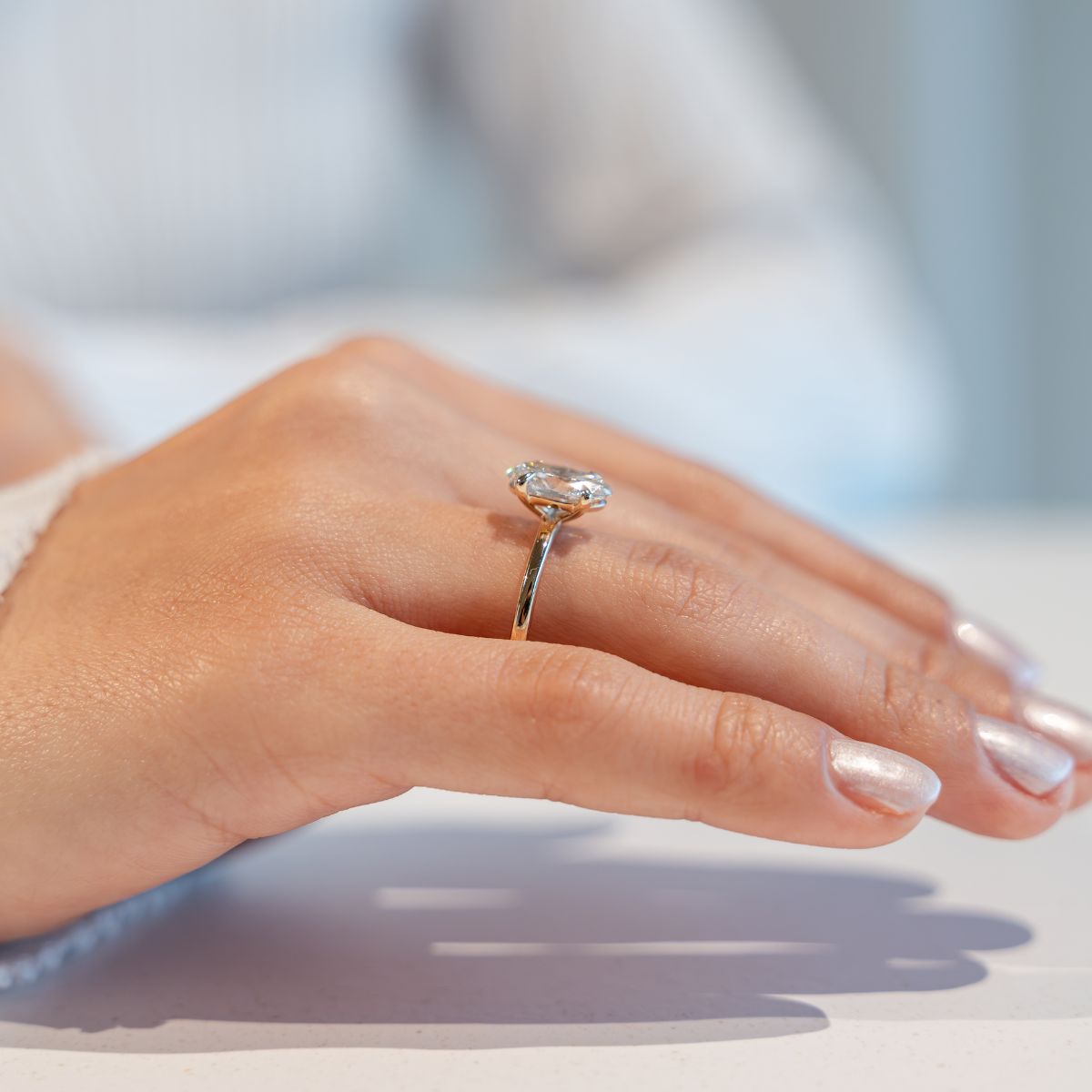 Model trägt weißgoldenen Verlobungsring mit Labor Diamant im Cushion -Schliff