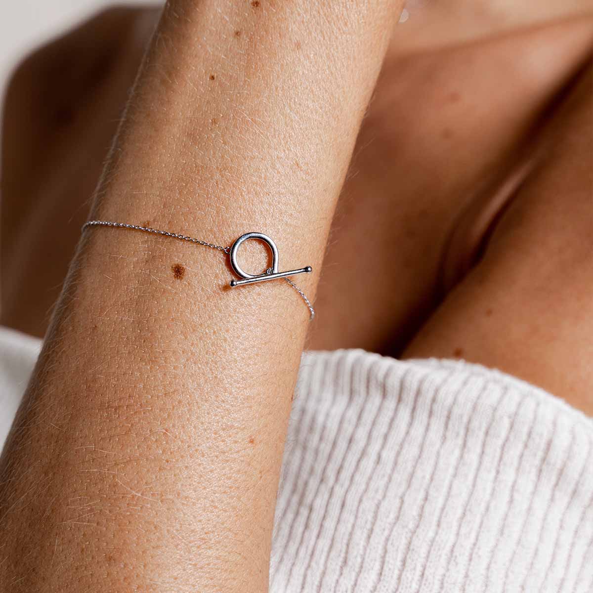 Handgelenk mit weißgoldenem filigranem Armband welches durch einen Knebelverschluss geschlossen wird