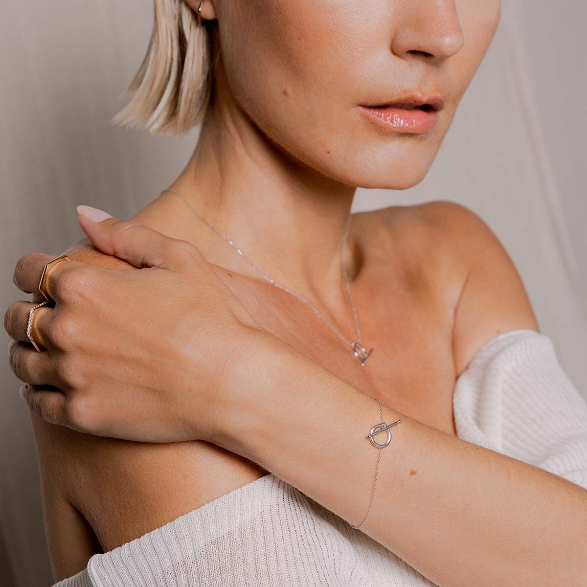 Model trägt weißgoldenes feines Armband was durch einen Knebelverschluss geschlossen wird