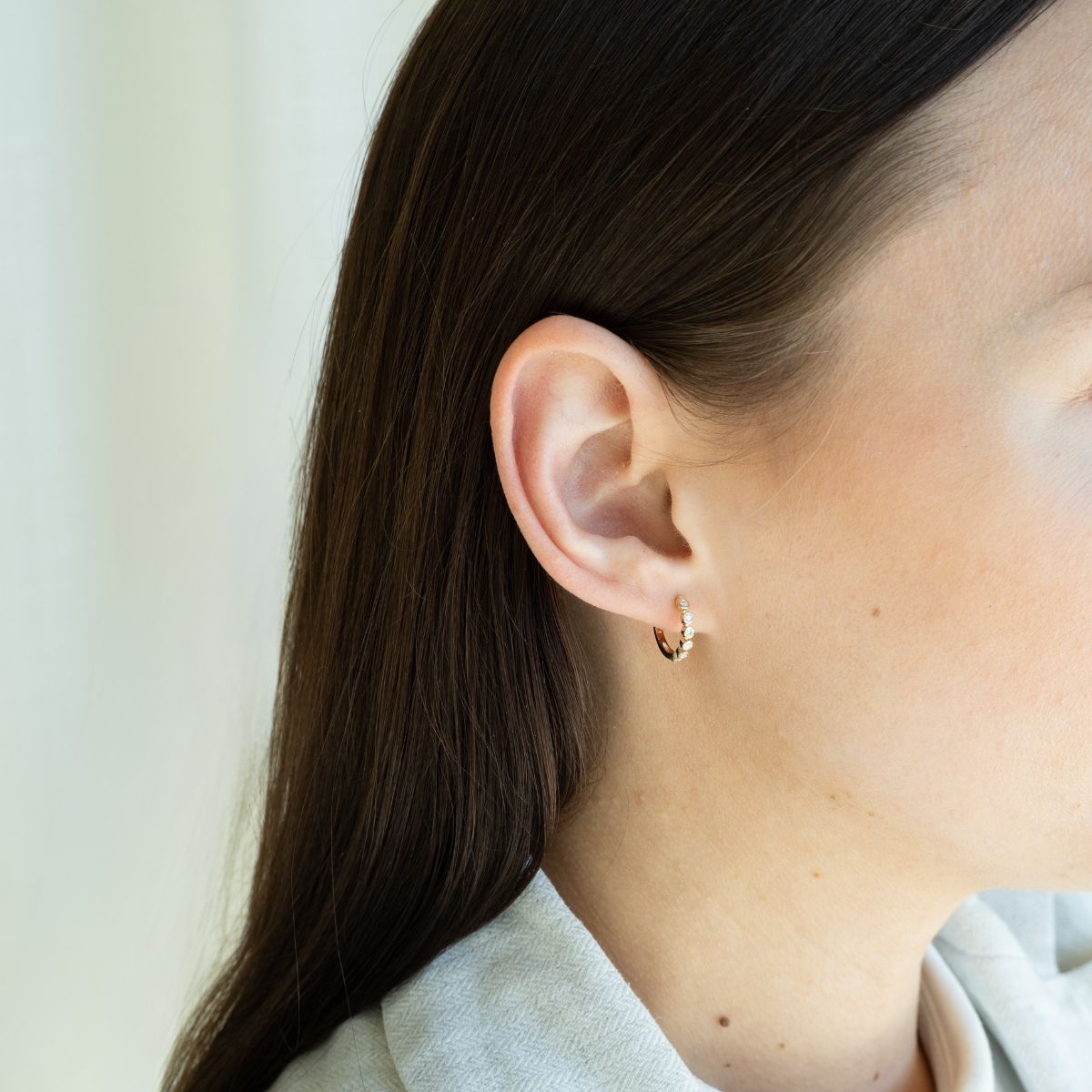 Model trägt gelbgoldene Kreolen mit Labor Diamanten im Rundschliff