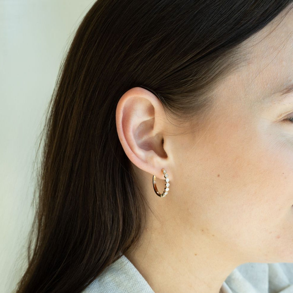 Model trägt gelbgoldene Kreolen mit acht Labor Diamanten im Rundschliff