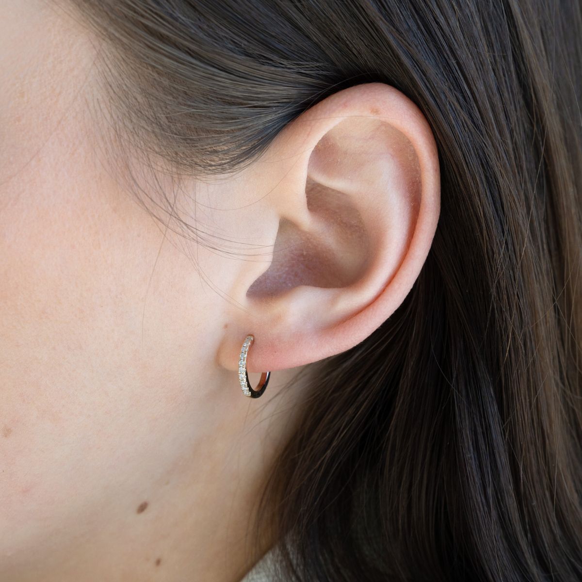 Model trägt gelbgoldene Kreolen mit runden Labor Diamanten