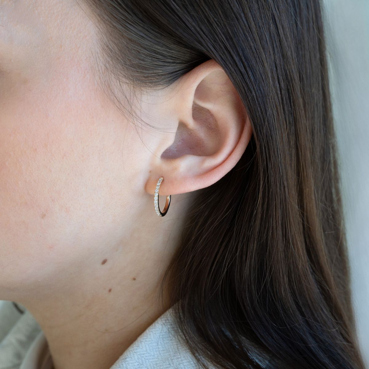 Model trägt gelbgoldene Kreolen mit Labor Diamanten in Rundschliff