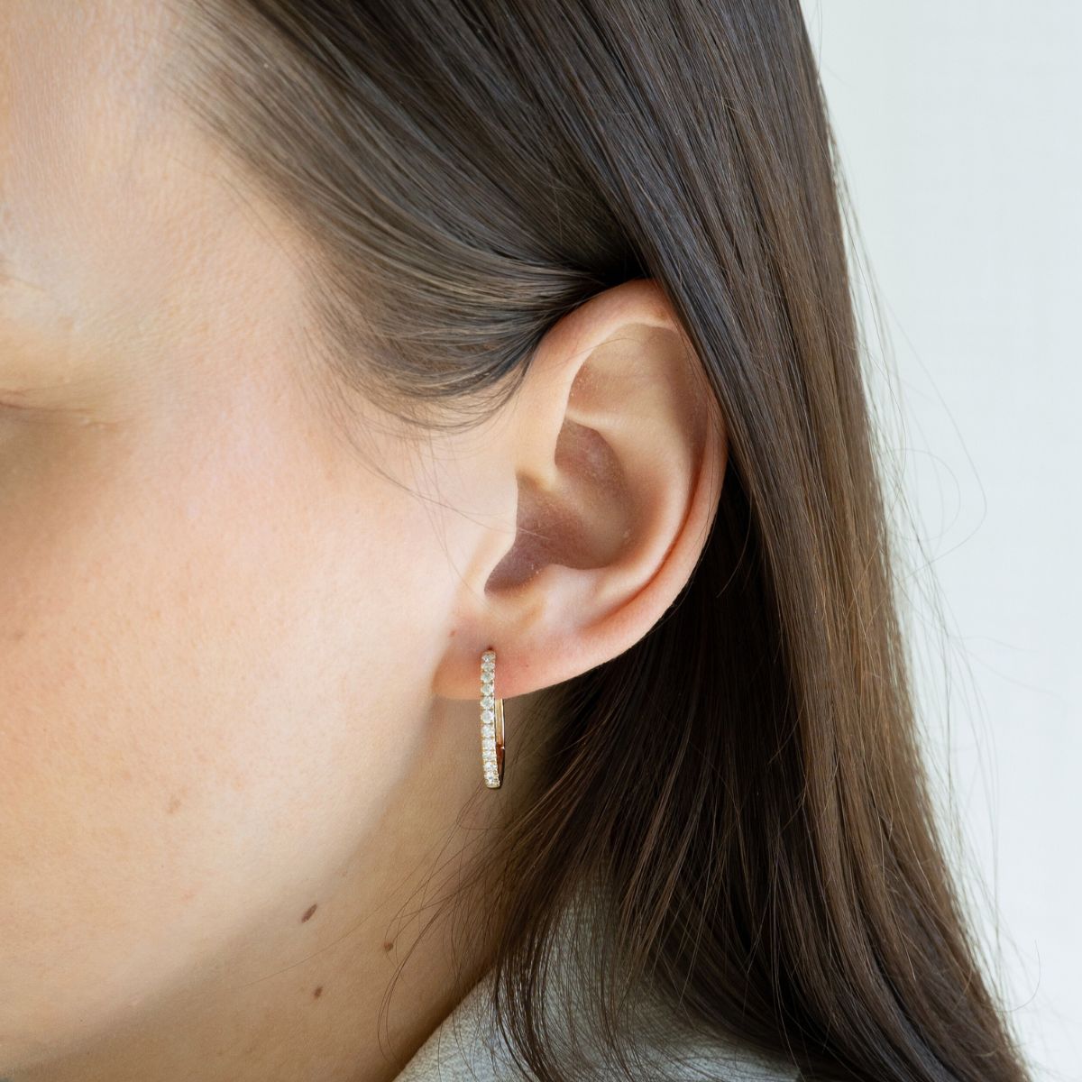 Model trägt gelbgoldene Kreolen mit Labor Diamanten in Rundschliff