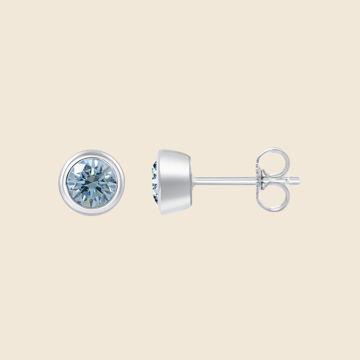 Ohrstecker in Weißgold mit rundem blauen Diamanten in Zargenfassung, Vorder- und Seitenansicht