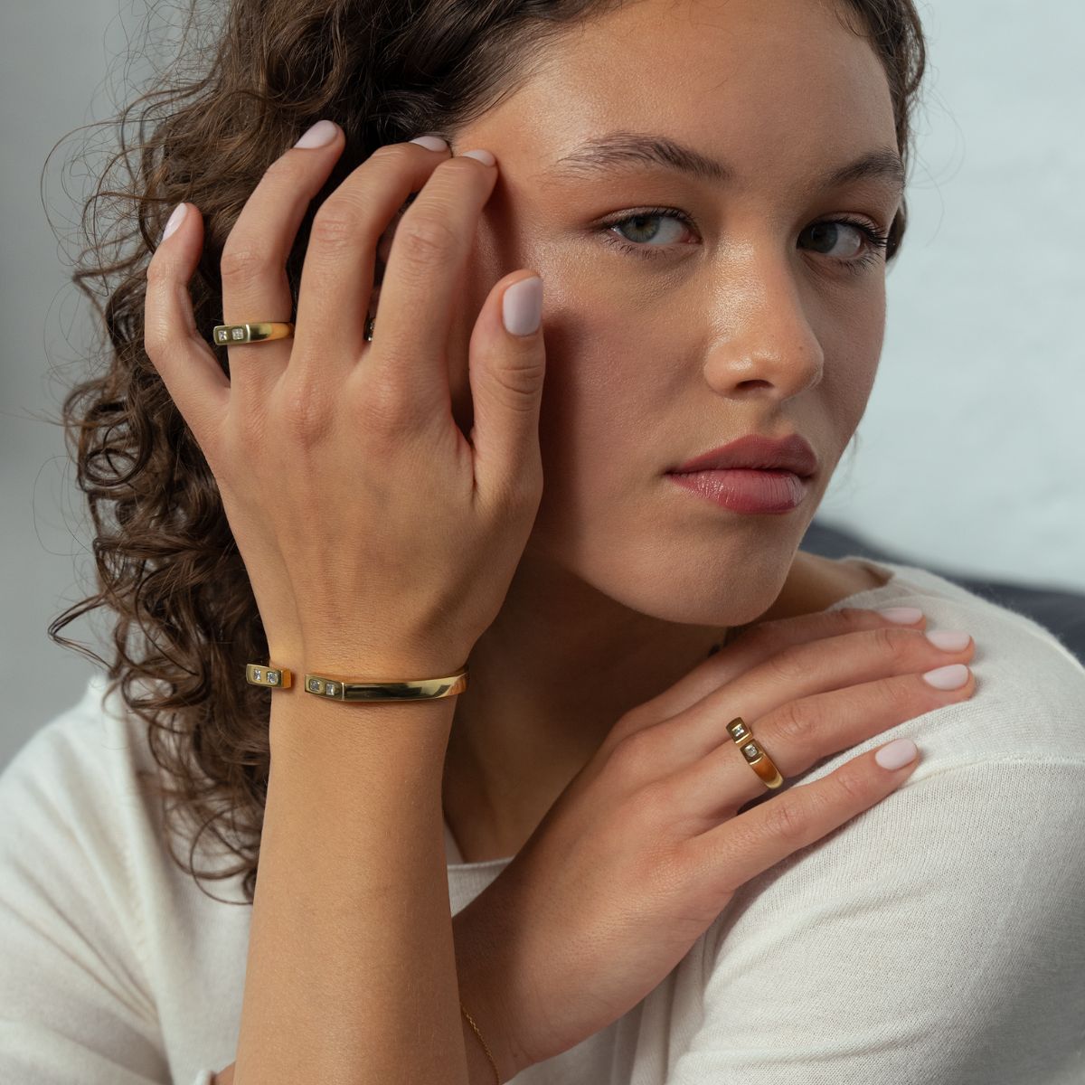 Model trägt vergoldeten Silberschmuck in Gelb mit Lab Diamanten an Handgelenk und Finger
