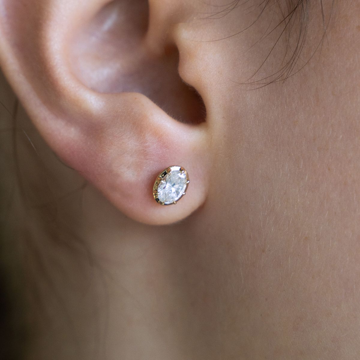 Model trägt Ohrstecker aus Gelbgold mit Lab Diamanten, facettenreich und funkelnd