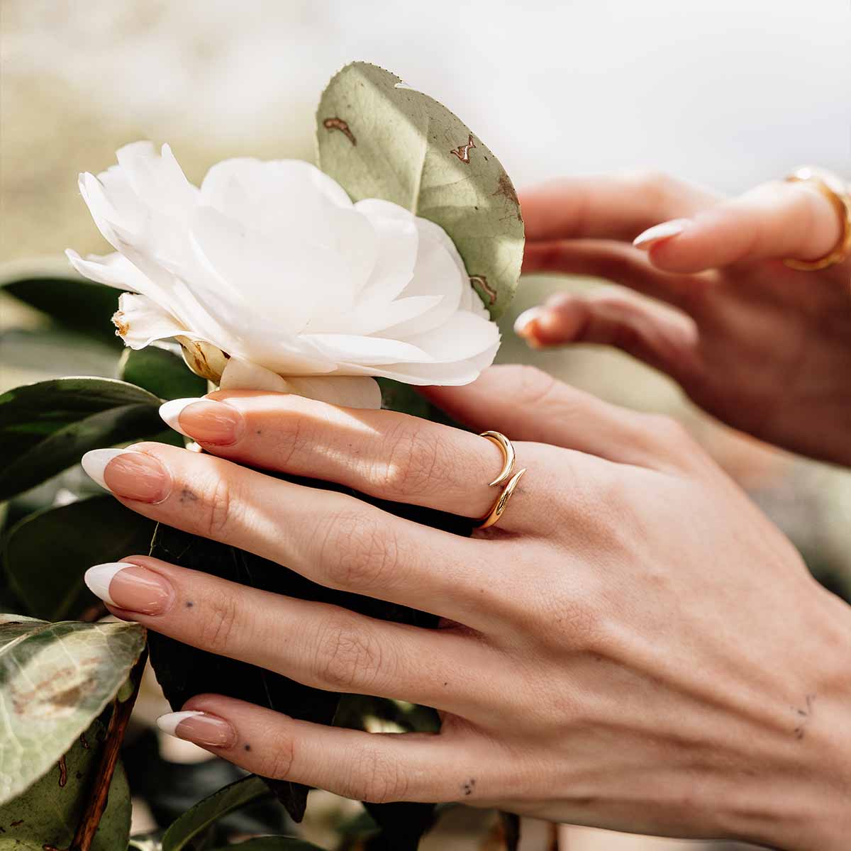 Model trägt offenen Ring in Gold am Zeigefinger