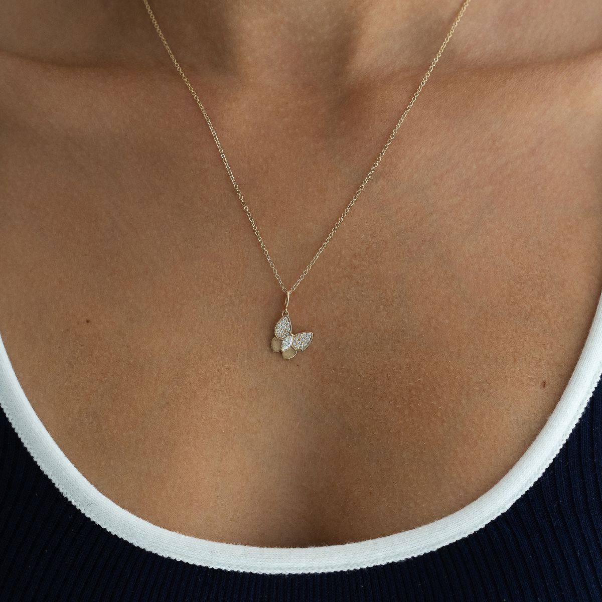 Model trägt Schmetterling Anhänger an einer Kette