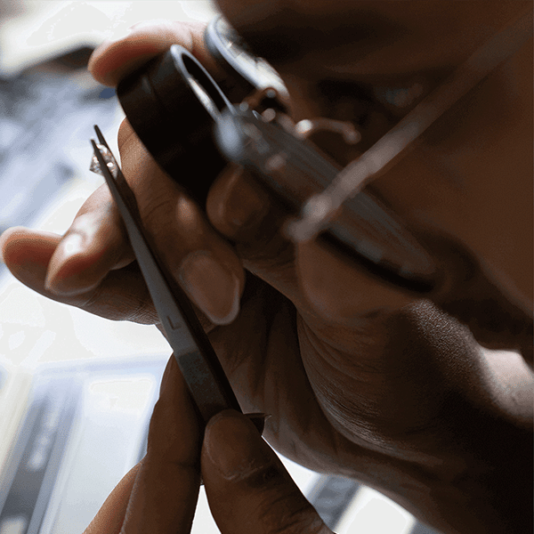 Diamant wird mit einer Lupe untersucht und begutachtet