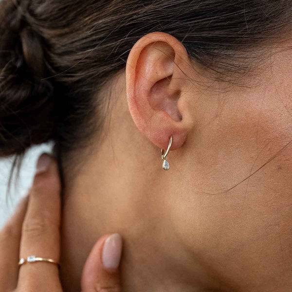 Model trägt goldenen Ohrhänger mit Lab Diamanten in Birnenschliff 
