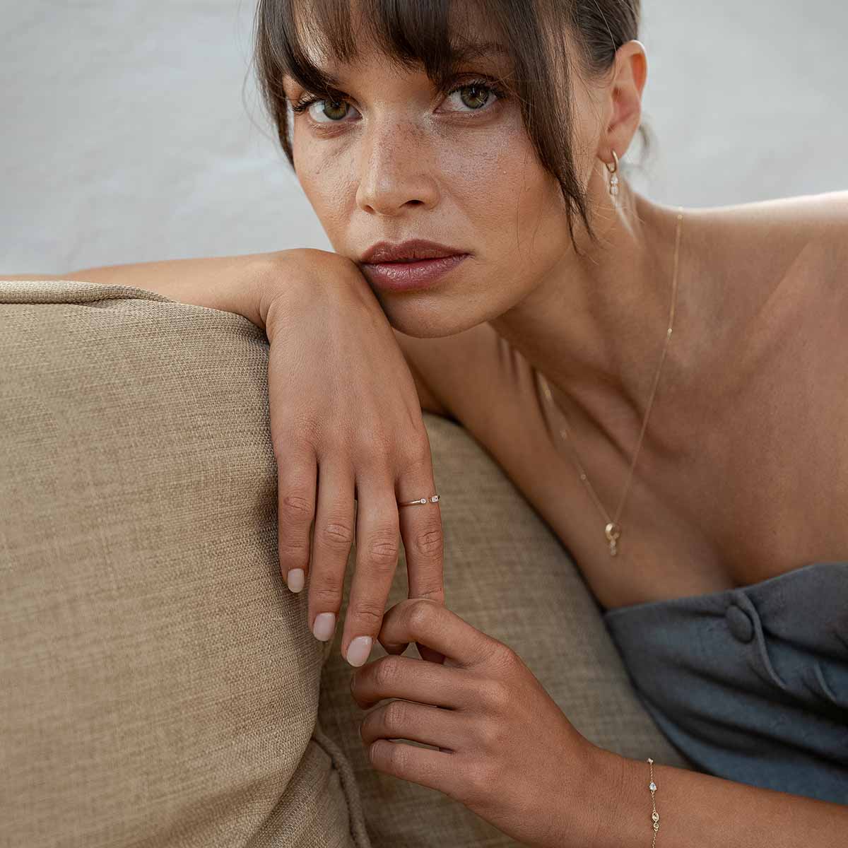 Weibliches Model trägt zartes 14k Gold Schmuck