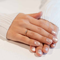 Hand mit schlichtem gelbgoldenen Verlobungsring mit runden Labor Diamanten