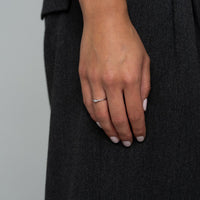 Model trägt weißgoldenen Verlobungsring mit gedrehtem Ringband