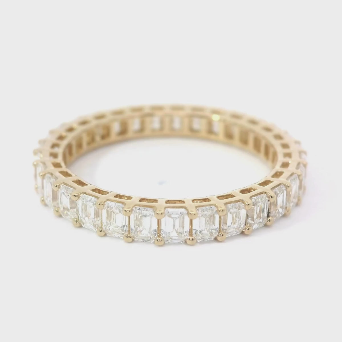 Video von drehendem gelbgoldenem Eternity Ring mit Labor Diamanten im Emerald Schliff, gefasst in Krappenfassung