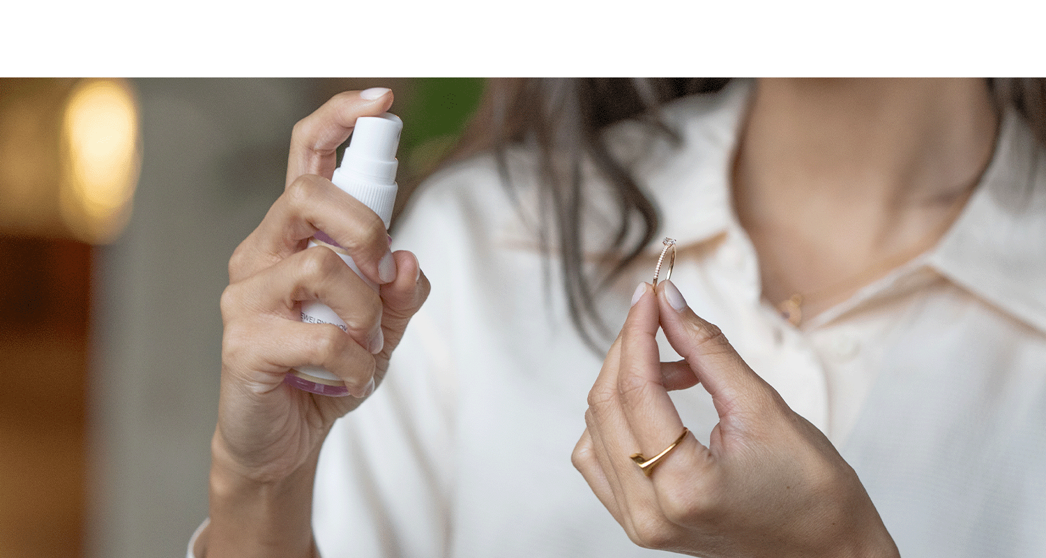 Frau hält eine Sprühflasche um den Ring zu säubern