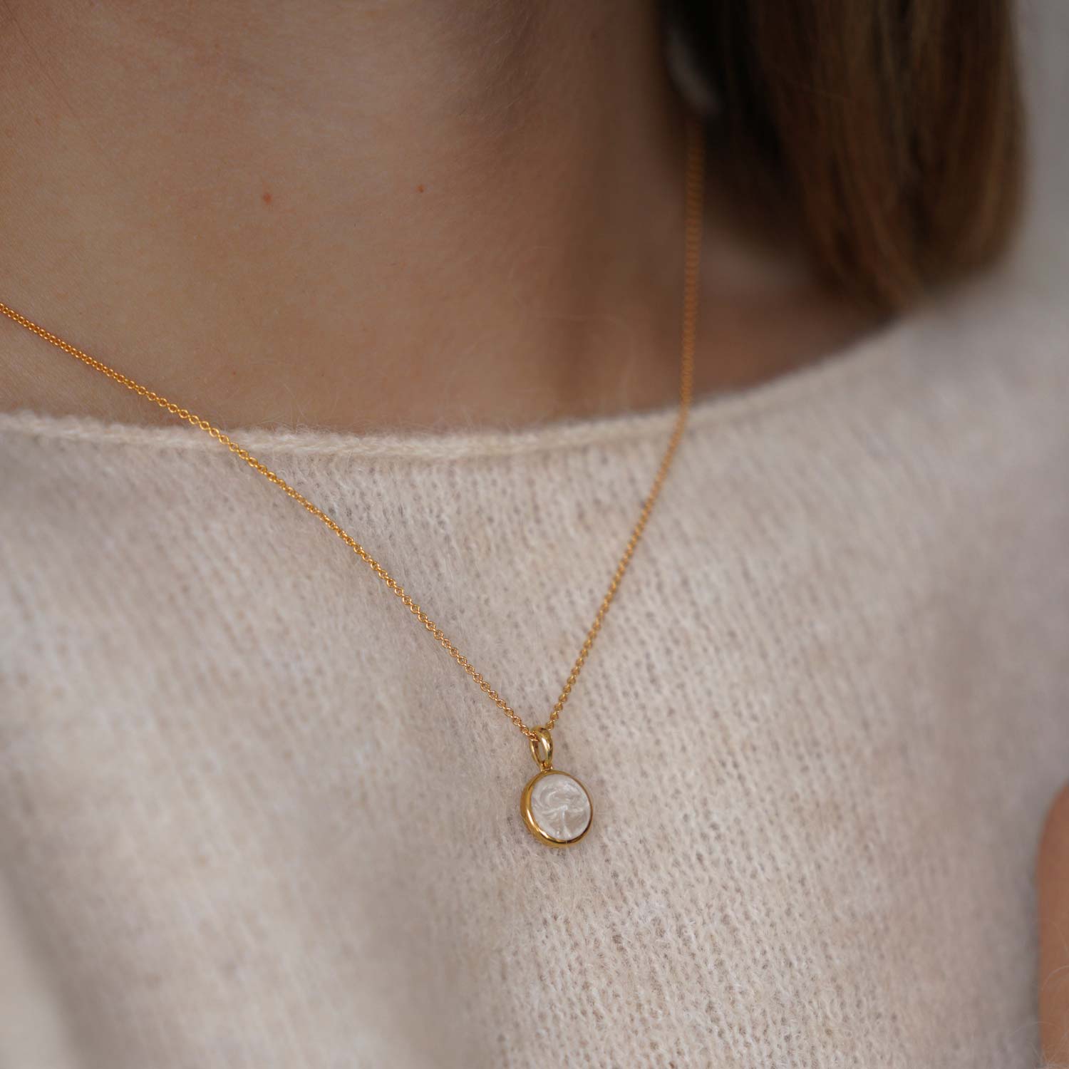 Model trägt goldene Halskette mit Perlweissem Anhänger