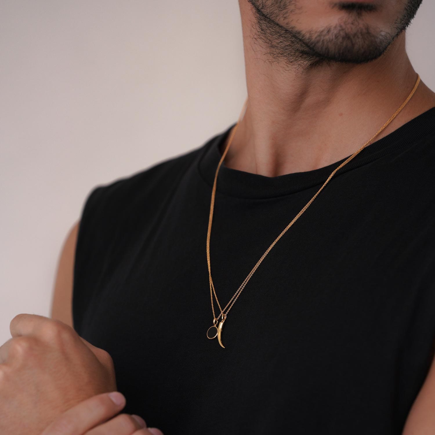 Model trägt goldene Halskette mit Schwarzem, Runden Anhänger