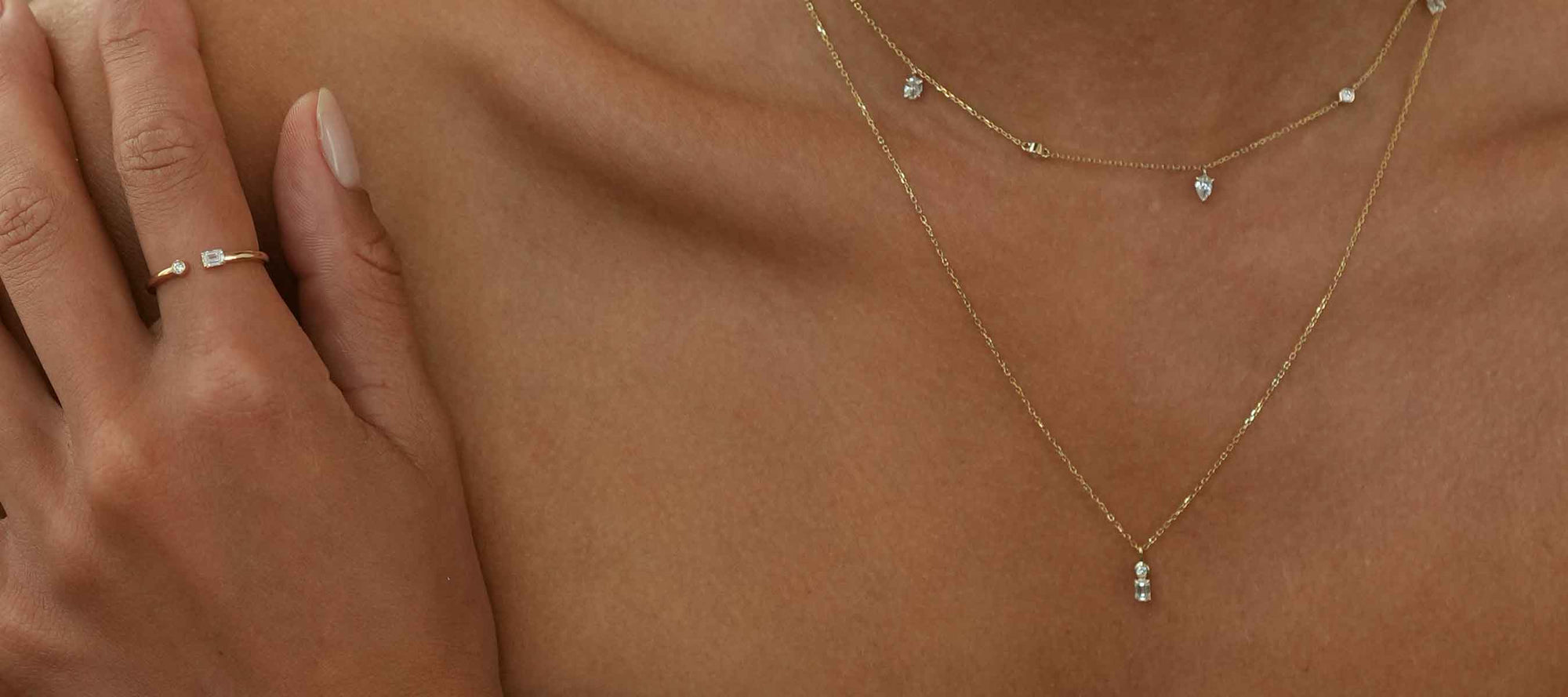Frau trägt zartes Schmuckset aus Ring und Ketten