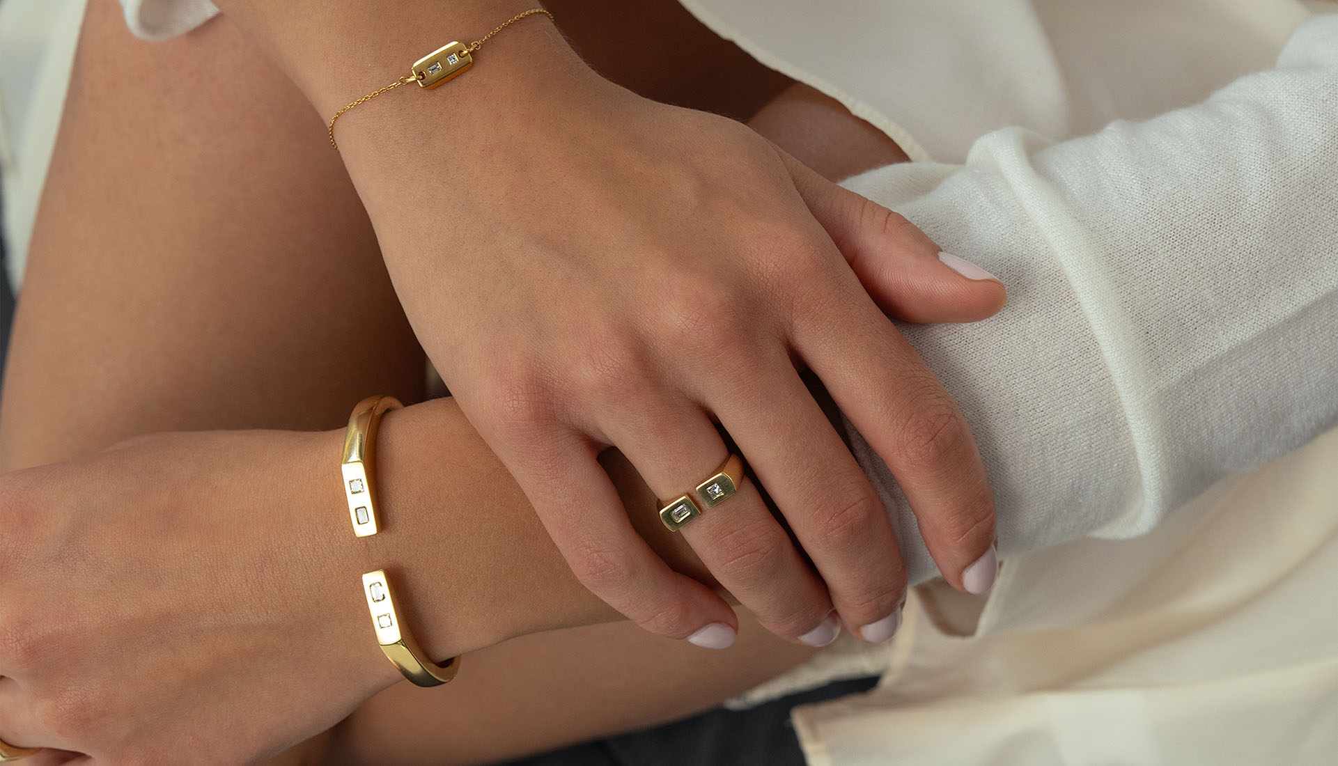 Frau sitzt auf Sofa und trägt Goldschmuck mit Diamanten