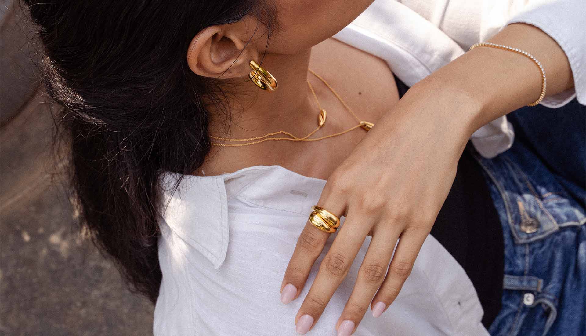 Model trägt Silberschmuck in Gelbgold