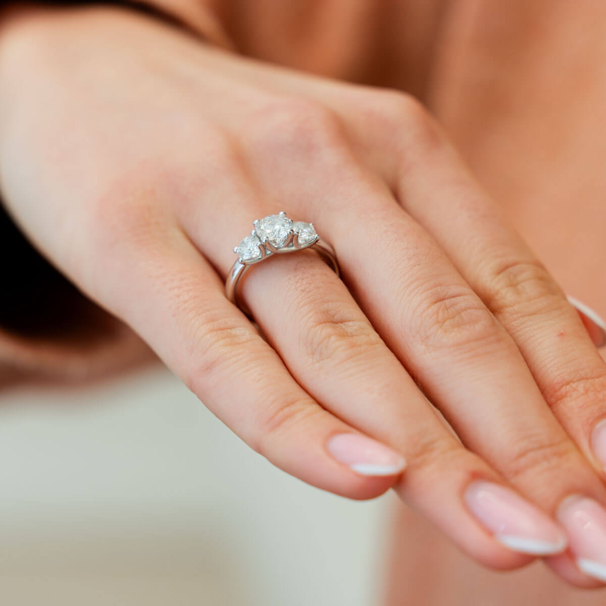 Drei-Stein-Diamantring an der Hand von der Seite