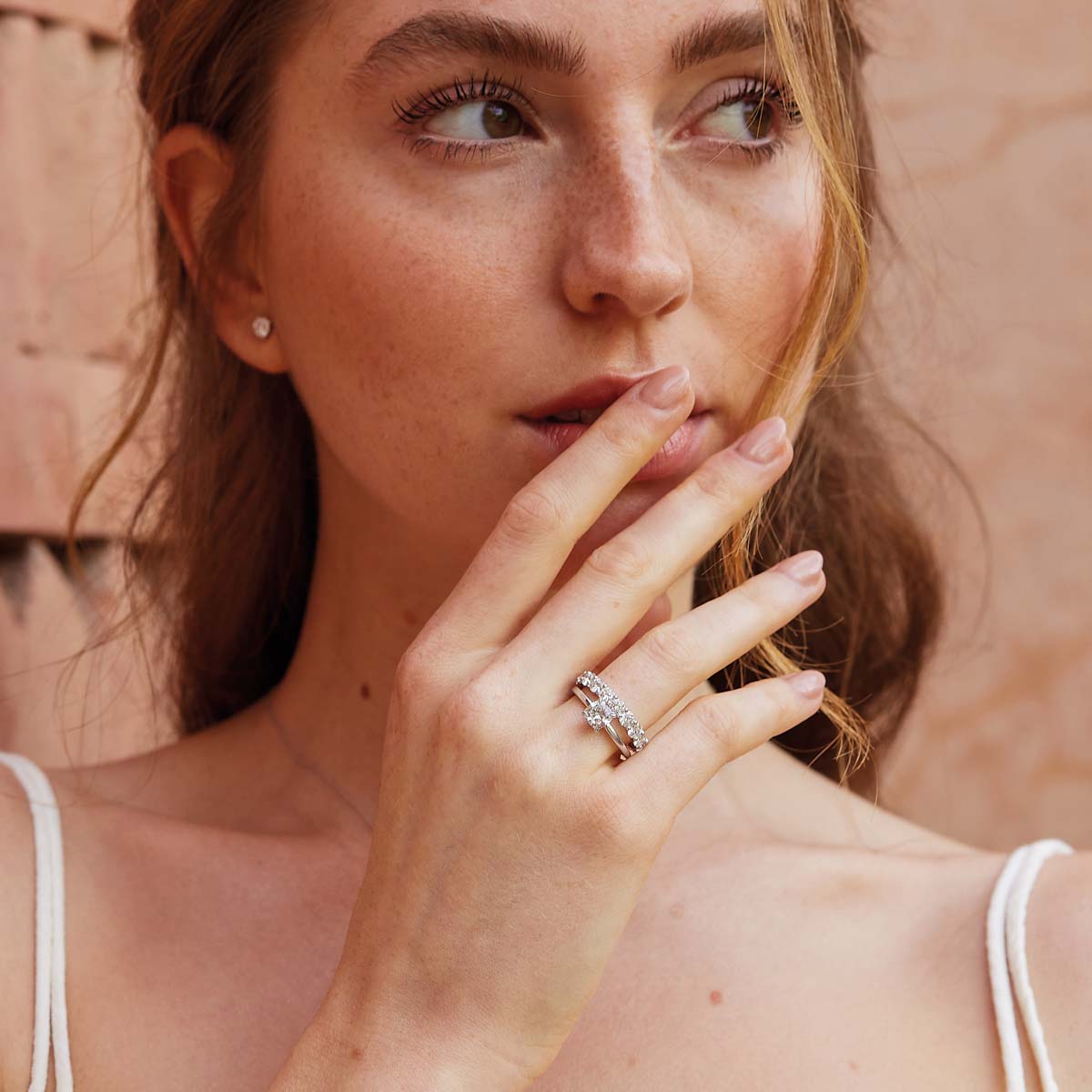 Model trägt eleganten Cushion-Verlobungsring mit einem Labor-Diamanten in Weißgold