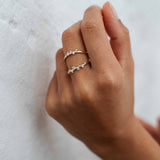 Model trägt gestapelte Ringe mit kleinen runden Lab Diamanten