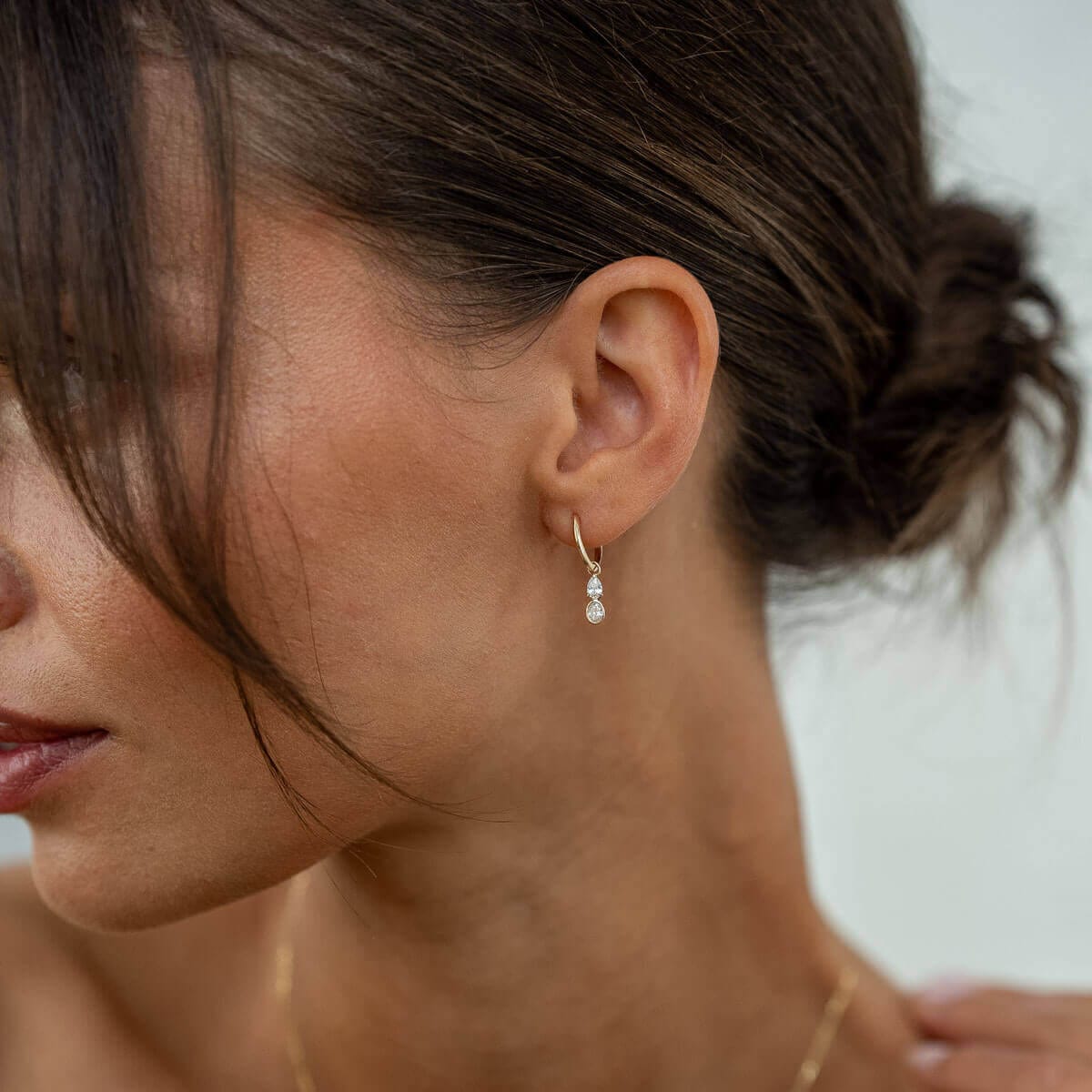 Model trägt Goldohrringe mit zwei Lab Diamanten