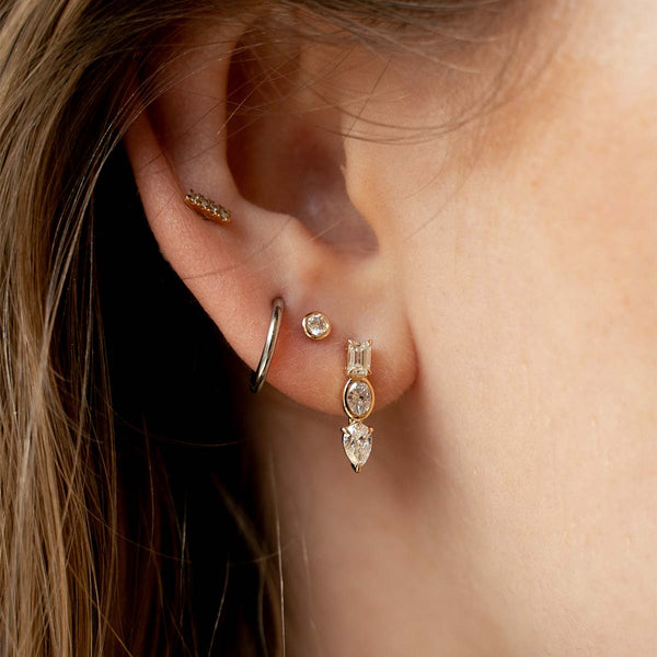 Model trägt Ohrringe in Gelbgold mit Lab Diamanten in Kessel- und Krappenfassung