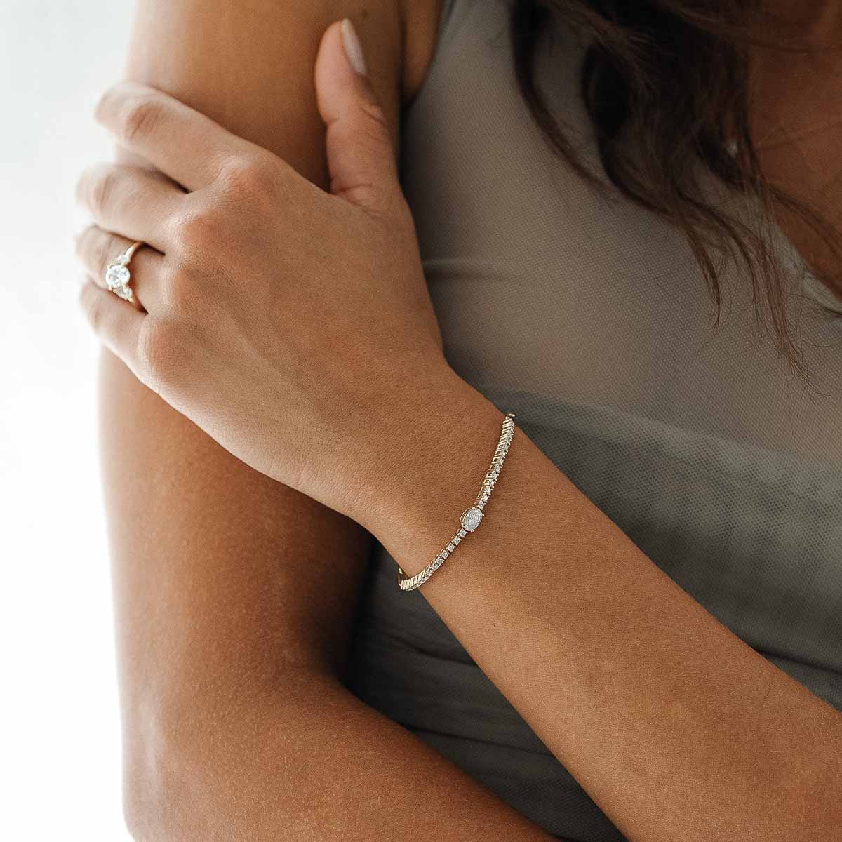 Model trägt Lab Diamantarmband mit großem zentralen Diamanten
