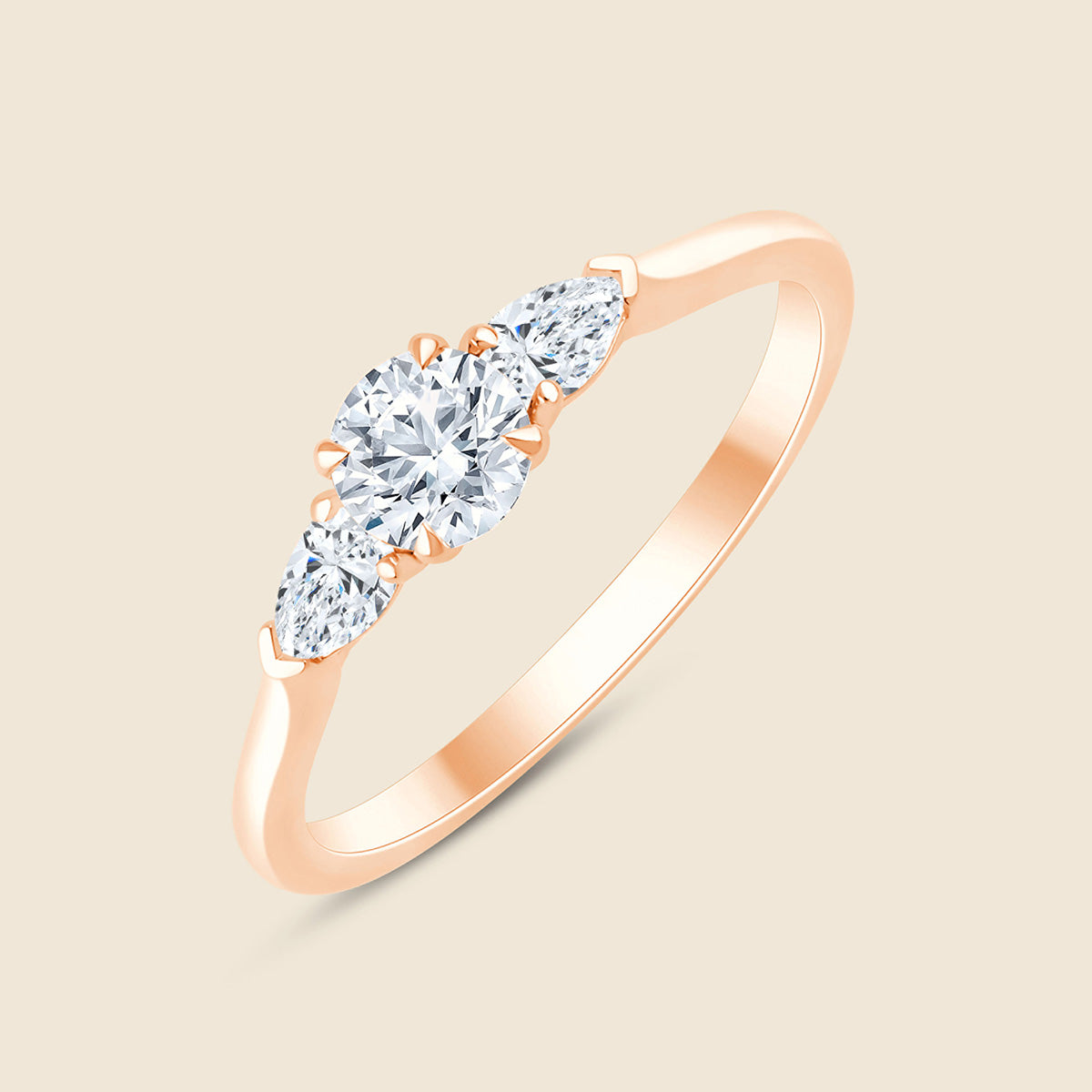 Rosegoldener Verlobungsring mit zentralem Lab Diamant im Rundschliff und zwei seitlichen Diamanten im Birnenschliff.