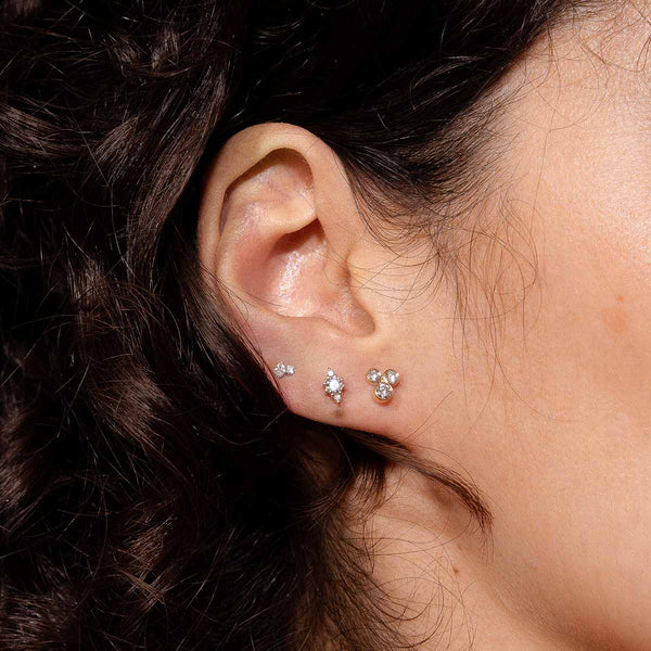 Ohr mit goldenem Lobe Piercing mit drei runden Lab Diamanten