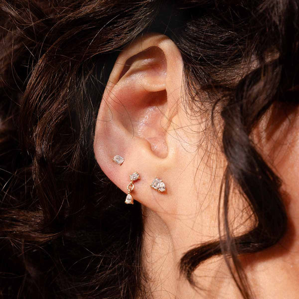 Ohr mit drei eleganten Piercings mit Diamanten