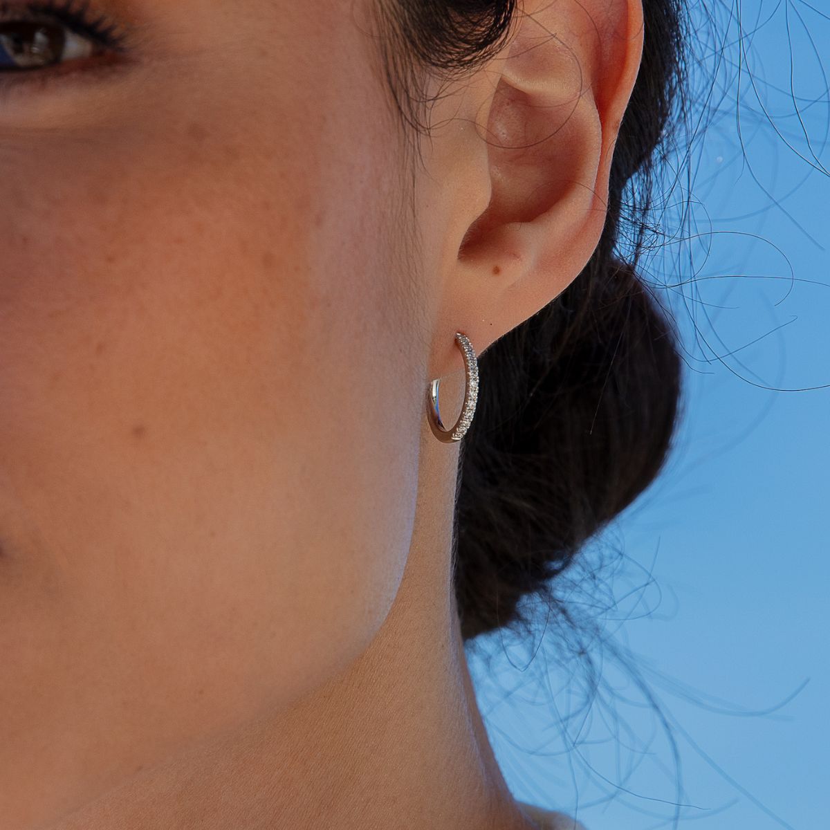 Model trägt gelbgoldene Kreolen mit  Labor Diamanten in Rundschliff