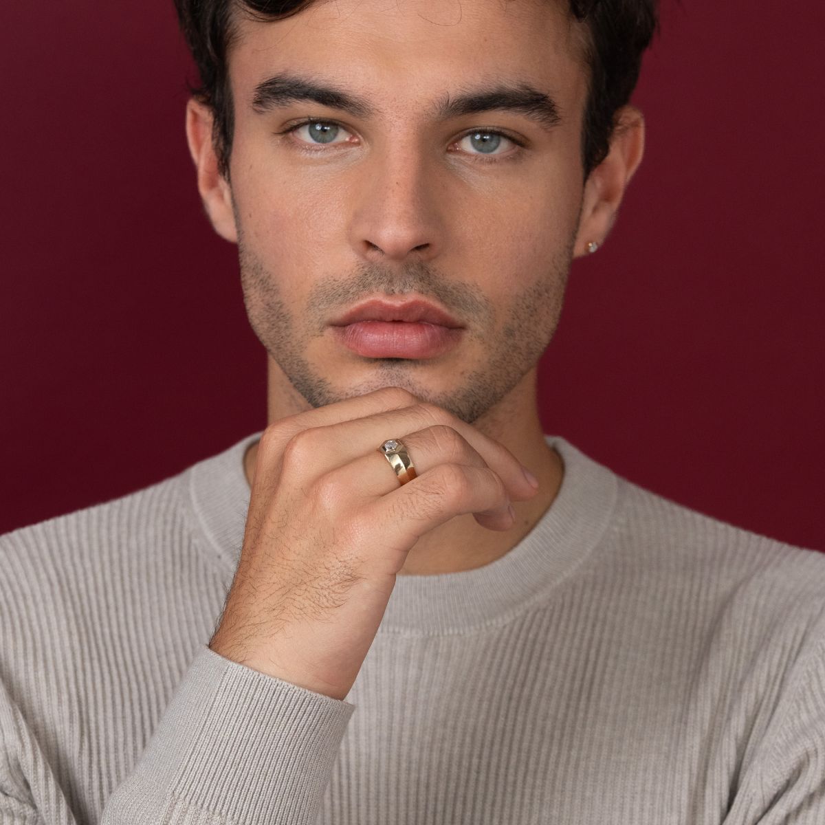 Model trägt goldenen Ring und Ohrstecker