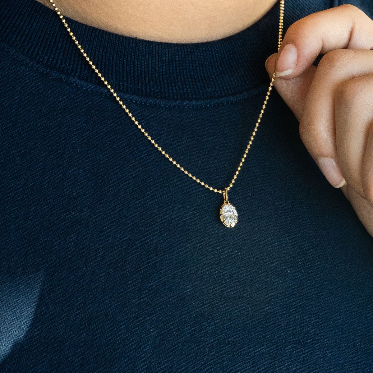 Model trägt Gelbgold Halskette mit Lab Diamant im Ovalschliff, zarte Fassung