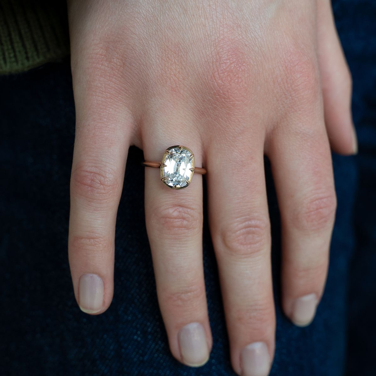 Model trägt Verlobungsring aus Gelbgold mit 2 Carat Lab Diamant im Kissenschliff, zentrale Fassung, seitlich