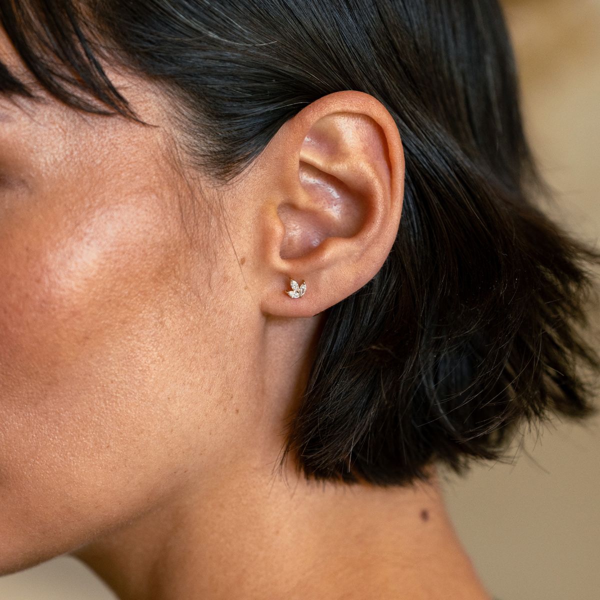 Nahaufnahme eines 14k Gold Piercings mit 3 Lab-Grown Diamanten im Marquise-Schliff