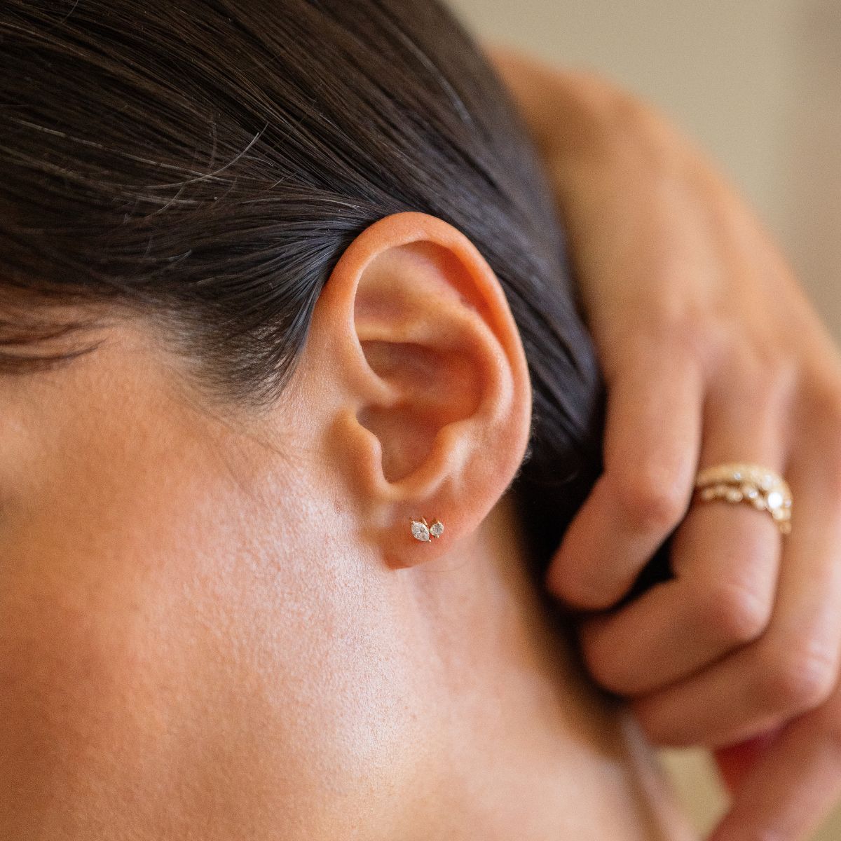 Nahaufnahme eines 14k Gold Piercings mit 2 Lab-Grown Diamanten im Marquise- und Rund-Schliff