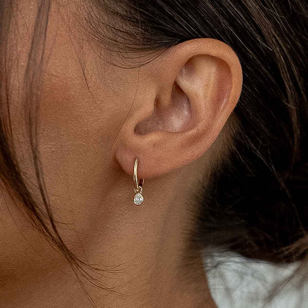 Model trägt Ohrring mit Lab Diamanten in Ovalschliff