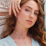 Model trägt goldenes Schmuckset aus Ohrringen, Ringen und Kette mit Keramikfarben