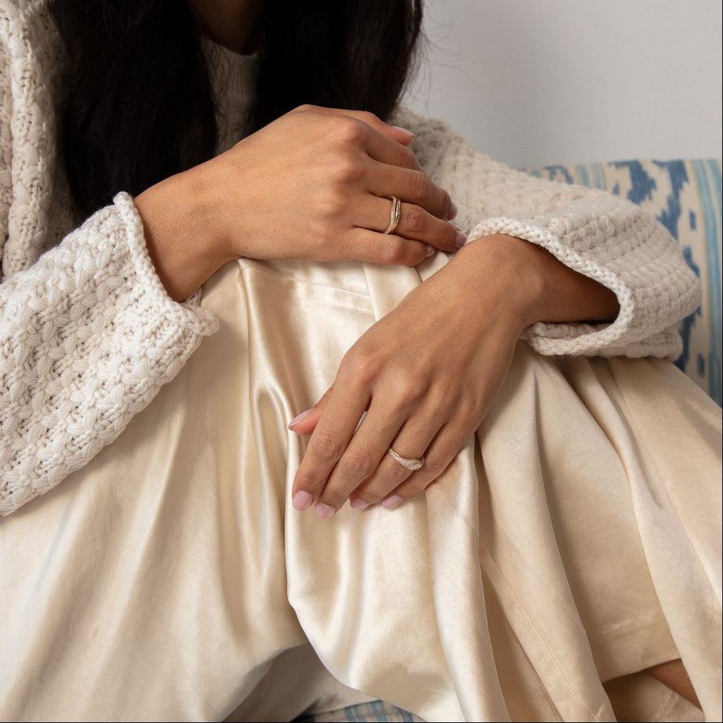 Model trägt einen Ring aus Gelbgold in organischer Wellenform