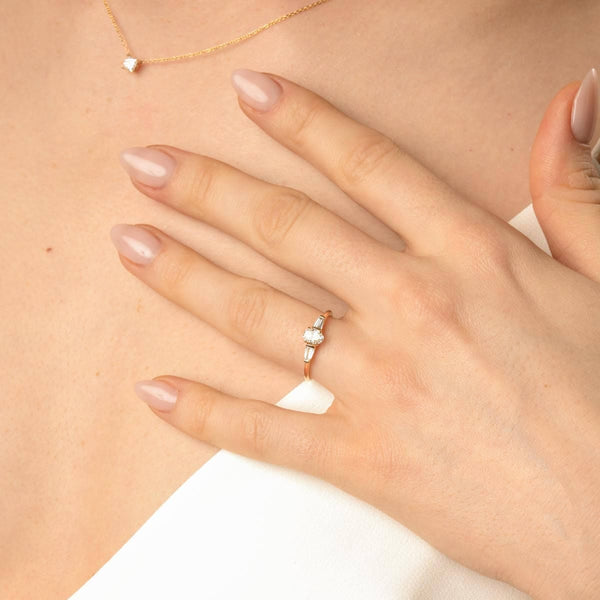 Brautmodel trägt Oval-Cut Verlobungsring in Gebgold