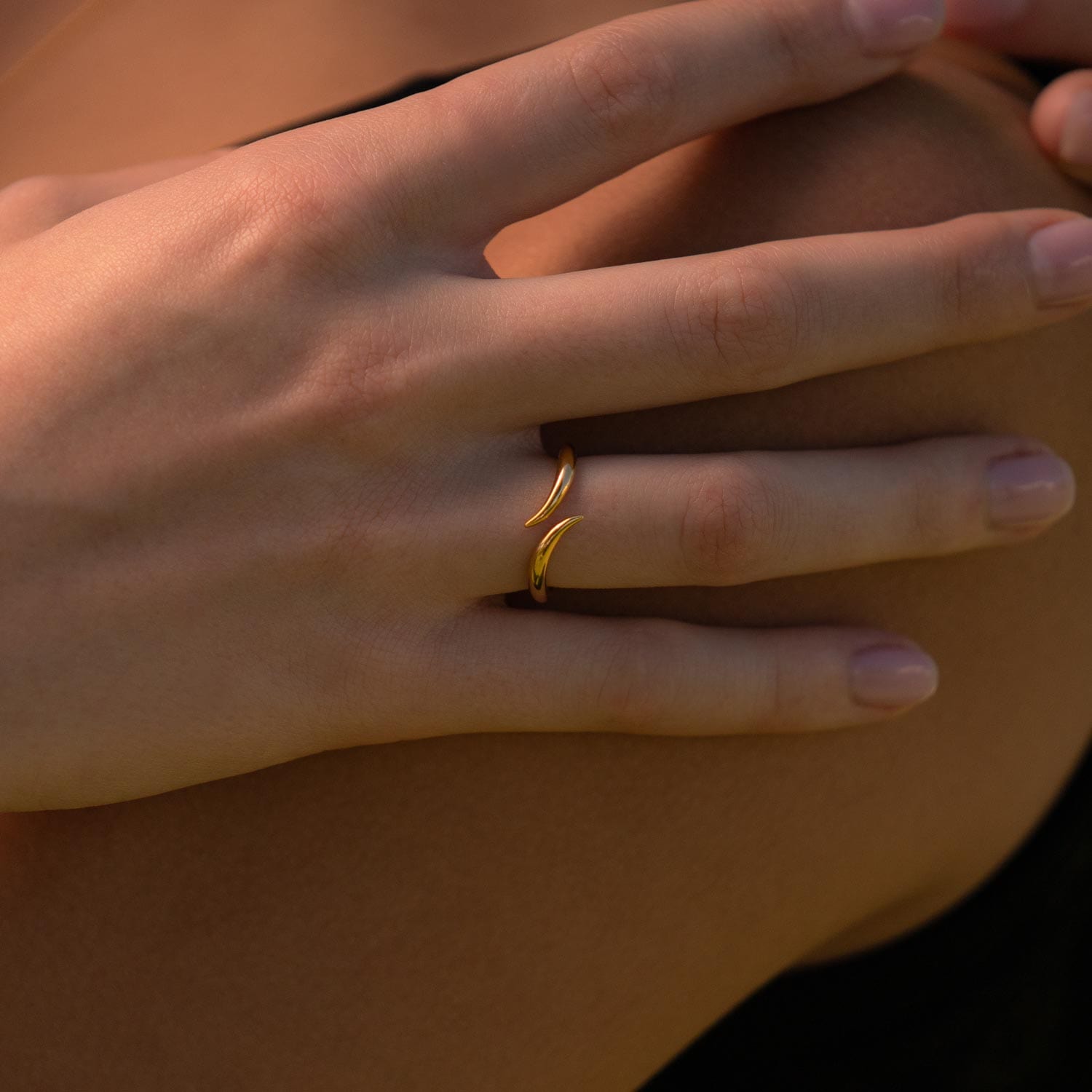 Model trägt offenen Ring dessen Enden spitz aneinander verlaufen