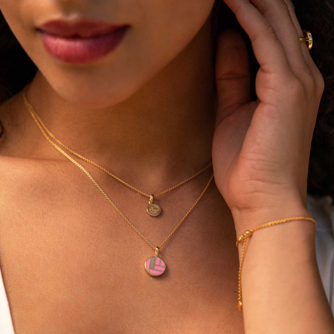 Model trägt Keramikkette mit Goldener Fassung und Pinkem Muster am Hals in Nahaufnahme